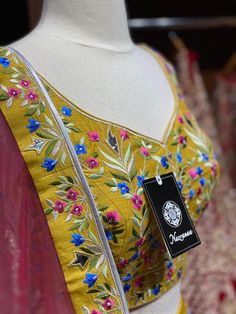 Saffron yellow lehenga elaborate work done all over the lehenga with multicolor resham detailing in floral design and highlighted with flux mirror and zari embroidery. Accomplished with similarly embroidered blouse and Look outstanding by styling a contrasting pink cut net dupatta. A saffron yellow that is not only dreamy but whimsical as well. Fabric : Silk Size: 38/M Ready to Ship! Festive Anarkali Choli With Dabka Work, Anarkali Choli With Mirror Work For Eid, Unstitched Anarkali Choli For Designer Wear, Anarkali Kundan Sharara With Dori Work, Designer Wear Sharara With Dupatta For Festivals, Designer Art Silk Anarkali Set With Mirror Work, Anarkali Chanderi Choli With Mirror Work, Navratri Dola Silk Sharara With Mirror Work, Anarkali Choli With Resham Embroidery