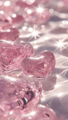 three pink heart shaped diamonds sitting on top of water