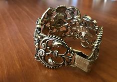 "This is: An original vintage 50s Jewelcraft bracelet. Stunning art nouveau style, with decorative heavy metal links - each signed. Hard to come by, a real rarity. Great condition. Height 5cm 7.5\" length Please see pics for size/weight/condition. Any questions, please message me, thanks. I accept all returns - if you are not happy with your item, please message me before leaving feedback and I will be happy to deal with your concerns. I try my best to be as accurate as possible in my listings, but occasionally I will make a genuine mistake and will rectify it very quickly, just let me know, thanks." Vintage Bronze Bracelet For Formal Occasions, Vintage Bronze Bracelets For Formal Occasions, Vintage Brass Cuff Bracelet For Formal Occasions, Vintage Gold Cuff Bracelet With Antique Finish, Vintage Antique Gold Cuff Bracelet, Vintage Bronze Cuff Bracelet With Intricate Design, Vintage Brass Bracelet With Intricate Design, Vintage Bronze Cuff Bracelet For Formal Events, Formal Metal Bracelets With Antique Finish