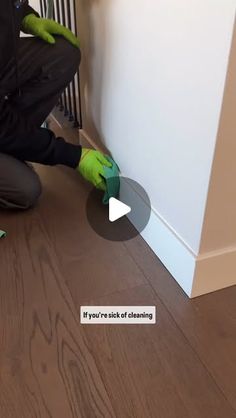 a person in green gloves is cleaning the floor