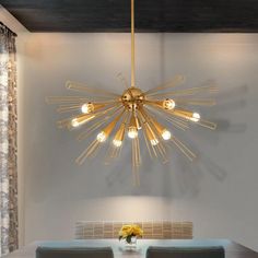 a dining room table with chairs and a chandelier hanging from it's ceiling