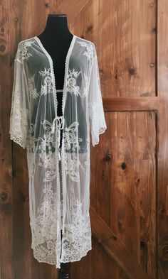 "An overlayering piece made with soft embroidered sheer lace. Makes for a super sweet cover up for any outfit! ONE SIZE FITS MOST - SMALL, MEDIUM, LARGE, XL Length: 46\" Bust: 24\" flat measure (tie front, one size fits all) Armhole: 14\" Get two items or more and your shipping is on us! Enter code FREESHIP at checkout! (US shipping only)" Bohemian Lace Beach Cover-up, White Lace Cover-up For Spring, Spring Festival Lace Cover-up, Bohemian Fitted Sheer Cover-up, Sheer Lace Beachwear Cover-up, White Wrap Cover-up For Spring, Fitted Lace Cover-up With Lace Trim, White Fitted Long Cover-up, Lace Fitted Vacation Cover-up