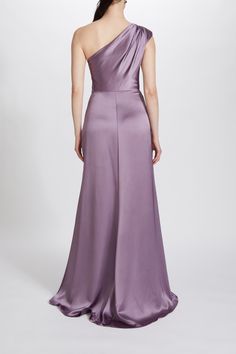 a woman in a long purple dress with one shoulder draped over her shoulders, looking back