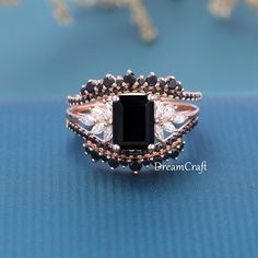 a black and white diamond ring sitting on top of a blue surface