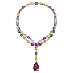 Crafted by master artisans with unparalleled skill and attention to detail, this necklace is meticulously arranged to create a harmonious symphony of color and light, further accentuated by the delicate sparkle of diamonds interspersed throughout the design. The dazzling array of peridot, blue topaz, citrine, iolite, and amethyst gemstones were each selected for their exceptional quality and vibrant brilliance all leading to the exceptional pear shape rubellite pendant. Indulge in the ultimate expression of luxury and sophistication with this extraordinary necklace, a timeless masterpiece that transcends trends and evokes a sense of timeless beauty and glamour. Dimensions: Interior Circumference: 13 1/2 inches Pendant Length: 3 inches Luxury Multicolor Necklace With Large Pendant, Drop Necklace, Amethyst Gemstone, Dream Jewelry, Pear Shaped, Gemstone Colors, Necklace Designs, Gemstone Necklace, Timeless Beauty