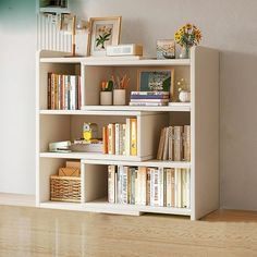 a bookshelf filled with lots of books on top of a hard wood floor