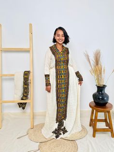 This stunning golden Habesha dress is designed to radiate cultural elegance. Featuring vibrant patterns and crafted from high-quality fabric, it's the perfect blend of tradition and modern style. Ideal for special occasions or everyday cultural pride. Key Features: Cultural Heritage: Adorned with exquisite handwoven details that honor Ethiopia's rich traditions. Flattering Design: The flowing silhouette ensures you look stunning at weddings, festivals, or any event where you want to shine. Ethical Craftsmanship: Handmade by skilled Ethiopian artisans, embracing tradition while making a bold fashion statement. Care Instructions: For best results, we recommend gentle hand washing. Shipping Information: Processing Time: 2 to 3 weeks Delivery: Shipping usually takes 3 to 5 days if you are in t Traditional Drape Dresses For Eid Rituals, Traditional Long Handloom Dress, Ceremonial Festive Floor-length Maxi Dress, Traditional Maxi Dress With Zari Work, Traditional Yellow Dress For Ceremonies, Traditional Gold Gown With Dabka Details, Yellow Dresses For Eid And Traditional Ceremonies, Traditional Yellow Kaftan For Eid, Traditional Yellow Kaftan For Festive Occasions