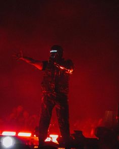 a man standing on top of a car in the dark