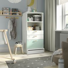 a baby's room with blue walls and white furniture