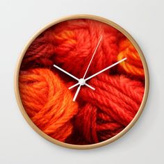 an orange and red clock with yarn on it