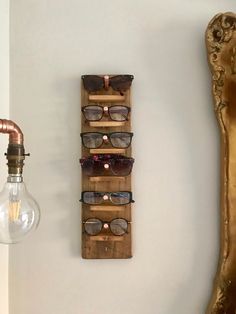 an eyeglass holder is mounted on the wall next to a light bulb