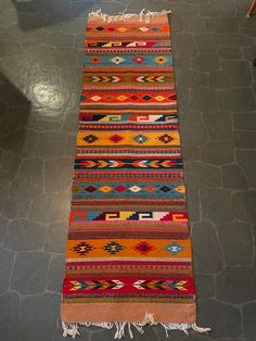 a multicolored rug with fringes on the floor