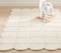 an elephant toy sitting on top of a white rug