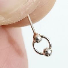 Enhance your style with this exquisite Double Ball 925 Sterling Silver Indian Nose Stud. Crafted from 100% authentic 925 sterling silver, our nose stud features a 2mm double ball design on a moving ring circle for that elegant touch. The 22g (0.6mm) x 6mm size ensures a secure and comfortable fit, perfect for daily wear. With its L-bendable closure, it provides easy and reliable application. Ideal for healed piercings, this unisex nose stud combines quality and fashion effortlessly. Purchase now Hypoallergenic Sterling Silver Round Nose Studs, Hypoallergenic Sterling Silver Nose Studs, Elegant Silver Nose Rings For Everyday, Dainty Silver Pierced Nose Rings, Dainty Silver Nose Rings, Silver Internally Threaded Round Nose Studs, Silver Hypoallergenic Round Nose Studs, Nickel-free Sterling Silver Nose Studs, Dainty Nickel-free Silver Nose Studs