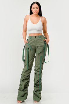 This distinct fashion choice merges the practicality of traditional utility wear with a touch of contemporary finesse. The pants are an ode to the functional attributes of cargo garments, designed to be robust with ample pocket space for practical use. The ruched detailing along the legs introduces a unique aesthetic twist, creating a gathered, textured effect that adds visual interest and a flair of modern sophistication. The inclusion of sleek, tonal belt straps further accentuates the waistli