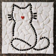 a mosaic tile with a cat's face on it and a red heart in the middle