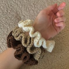 someone is holding their hand with crocheted wrist warmers on top of each other