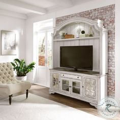 a living room with a couch, chair and television on the entertainment center in it