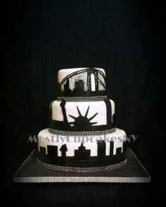 a three tiered cake with the statue of liberty in the middle on a black background