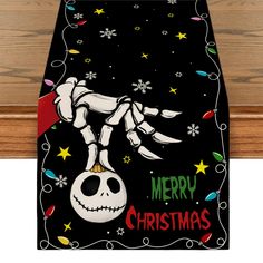 a christmas table runner with a skeleton on it's head and the words merry christmas