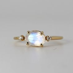 White Oval Celestial Rings, Fine Jewelry Moonstone Rings In Oval Cabochon Shape, Fine Jewelry Yellow Gold Moonstone Ring, Oval Moonstone Fine Jewelry Ring, Fine Jewelry Oval Moonstone Ring, Yellow Gold Oval Moonstone Ring, Dainty Oval Moonstone Rings, Oval Moonstone Ring For Anniversary, Oval Cabochon Moonstone Ring For Wedding In Yellow Gold