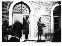 an old black and white photo of two men standing in front of a door