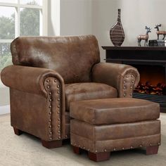 a brown leather chair and ottoman in front of a fireplace