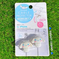 two earbuds sitting in the grass next to an iphone charger and packaging