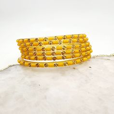 Add a touch of elegance to your ensemble with Priya Glass Bangles. The pale orange/yellow and muted gold colors exude a subtle sophistication. Handcrafted with precision and quality, these bangles are a must-have addition to your jewelry collection. *Sold as a six-piece set.*To prevent any potential damage, please put on each glass bangle individually. For a snug fit, we suggest sizing up from your usual bangle size. Traditional Yellow Bangle For Diwali, Festive Adjustable Yellow Bangle, Cheap Yellow Festive Bangle, Elegant Adjustable Yellow Bangle, Yellow Hand-strung Bangle Bracelets, Glass Bangles, Pale Orange, Bangles Jewelry, Instagram Icons