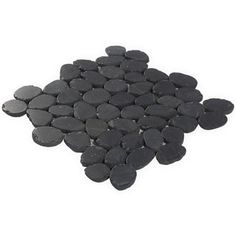 a pile of black stones sitting on top of a white floor next to each other