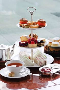 three tiered trays filled with different types of desserts and pastries on top of a table