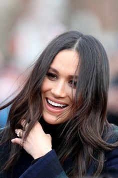 a woman with long hair smiling and looking at the camera