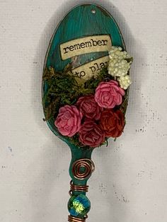 a green spoon with flowers on it and a sign that says, remember to dial