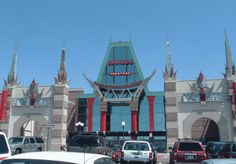 cars are parked in front of a building with an elaborate design on the top and sides