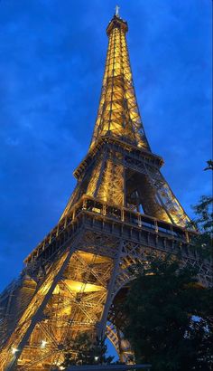 the eiffel tower lit up at night with lights on it's sides