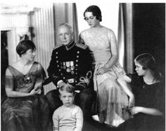 an old black and white photo of three people with a young child sitting on the floor