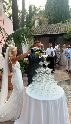 a bride and groom toasting with wine glasses on a table in front of their guests