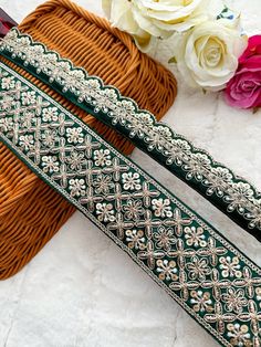 two green and white beaded belts next to flowers