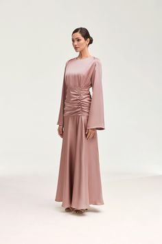 Indulge in luxury and sophistication with our Shams Satin Side Rouched Maxi Dress in Dusty Rose. The elegant hue is enhanced by the side rouched detailing, creating a flattering silhouette. The dramatic flare sleeves add a touch of drama and femininity to this must-have piece. Model is 5'7" and is wearing size XS/58". White Dress Formal, Dresses Flowy, Nikkah Dress, Dusty Rose Dress, Flare Sleeves, Engagement Dresses, Dress Dusty, Dress Satin, Kids Outerwear