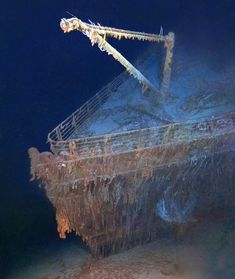 an old rusted ship in the ocean with seaweed on it's hull