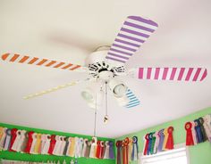 the ceiling fan is hanging from the ceiling in the room with colorful curtains on it