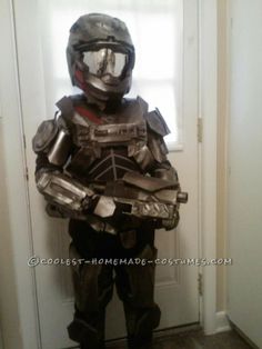 a person in a costume that looks like a man with armor and helmet standing next to a door