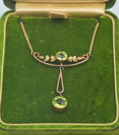 "Antique Art Nouveau Edwardian 9k Two-Tone Gold Peridot Dangling Pendant Necklace with a floral motif circa 1905 with a matching antique green felt necklace box! Necklace length is 19\" (including the pendant piece). We can always remove links in the necklace to reduce the length before shipping! The top pendant is 1.25\" long. The dangling pendant piece is 1.1\" long. The piece in total weighs 5.1 grams. The pendant is marked 9ct and the necklace is marked 9kt. In excellent antique condition. F Elegant Engraved Necklace For May Birthstone, Formal Green Engraved Necklace, Elegant Engraved Necklace With May Birthstone, Gold Art Nouveau Necklaces For Formal Occasions, Gold Art Nouveau Necklace For Formal Occasions, Green Victorian Necklace For Wedding, Art Nouveau Gold Necklace For Formal Occasions, Elegant Green Engraved Jewelry, Formal Art Nouveau Gold Necklace