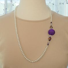 White pearl necklace with a purple mesh ball surrounded by Chinese crystal rondelle; Chinese teardrop in iridescent purple; a smaller Chinese crystal rondelle; Czech round in purple metallic; and finished with a soft purple pearl rice-shaped bead. The pearls are 6mm rounds; the mesh ball is 24mm; the rondelle beads are 8x12mm; the teardrop beads are 14x8mm; the smaller rondelles are 4x6mm; the rounds are 6mm and the final rice-shaped beads are 4x6mm. The necklace length is 29".  Lobster clasp, rings and crimps in sterling silver. N0026 Purple Pearl Single Strand Jewelry, Purple Pearl Single Strand Necklace, Purple Single Strand Pearl Jewelry, Purple Beaded Necklace With Large Beads For Party, Adjustable Beaded Purple Pearl Necklace, Adjustable Purple Beaded Pearl Necklace, Elegant Purple Necklace With Large Beads, Adjustable Purple Pearl Necklace With Round Beads, Adjustable Long Purple Beaded Necklace