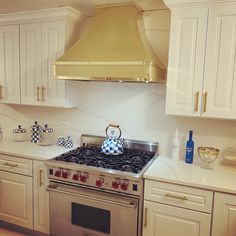 a stove top oven sitting inside of a kitchen next to white cabinets and counter tops