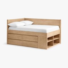 a bed with drawers underneath it and a white pillow on the top of one end