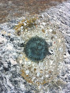 there is a rock with writing on it and gravel around the hole in the middle