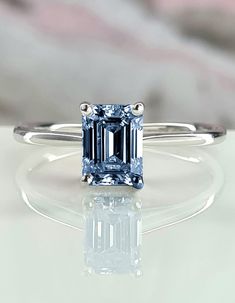 a blue diamond ring sitting on top of a table