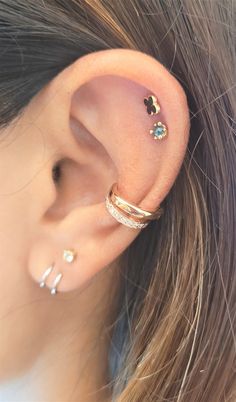 a close up of a person's ear with two different piercings on it