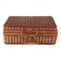 a brown wicker box with handles and straps on the top, sitting against a white background